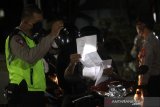 Petugas memeriksa pengendara yang ingin masuk ke dalam Kota di Pos Pemeriksaan Pembatasan Sosial Berskala Besar (PSBB) Jalan Ahmad Yani Kilometer enam, Banjarmasin, Kalimantan Selatan, Rabu (13/5/2020) malam. Saat pemberlakuan jam malam pukul 21.00 Wita hingga 06.00 Wita akses masuk maupun keluar Kota diperketat dengan akses terbatas sesuai dengan Peraturan Wali Kota Banjarmasin nomor 37 tahun 2020 tentang pelaksanaan PSBB di Kota Banjarmasin. Foto Antaranews Kalsel/Bayu Pratama S.