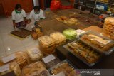 Pekerja mengemasi kue kering di industri rumahan yang ada di Jalan Gubernur Suryo Kabupaten Jombang, Jawa Timur, Kamis (14/5/2020). Pengusaha kue kering rumahan tersebut tetap produksi walaupun mengalami penurunan penjualan dan produksi sekitar 50 persen dibanding tahun lalu akibat pandemi virus Corona dengan melakukan inovasi memasarkan kue kering yang dijual mulai harga Rp20 ribu-Rp80 ribu per toples tersebut melalui sosial media. Antara Jatim/Syaiful Arif/zk