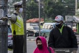 Warga melintasi sebuah Patung Polisi Lalu Lintas yang dipasangkan masker di Bandung, Jawa barat, Jumat (15/5/2020). Patung yang menjadi salah satu simbol ketertiban berlalu lintas Kota Bandung tersebut dipasangkan masker guna meningkatkan kesadaran masyarakat untuk wajib menggunakan masker di masa pandemi COVID-19 agar tidak tertular saat beraktivitas di luar Rumah. ANTARA JABAR/Novrian Arbi/agr