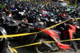 Ratusan kendaraan bermotor milik warga yang terjaring razia terparkir di halaman Polresta Sidoarjo, Jawa Timur, Minggu (17/5/2020). Kepolisian Resor Kota Sidoarjo Jawa Timur berhasil mengamankan 224 kendaraan bermotor yang diduga digunakan saat balap liar motor di akses jalan exit tol porong saat pemberlakuan pembatasan sosial berskala besar (PSBB) dan melakukan pembinaan terhadap 500 pemuda yang turut terjaring dalam razia itu agar tidak mengulangi perbuatannya. Antara Jatim/Umarul Faruq/zk