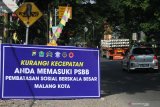 Sebuah mobil melintas di depan tanda pemberlakuan Pembatasan Sosial Berskala Besar (PSBB) di Jalan Raya Balearjosari, Malang, Jawa Timur, Minggu (17/5/2020). Pemerintah resmi memberlakukan Pembatasan Sosial Berskala Besar (PSBB) untuk kawasan Malang Raya yakni Kota Malang, Kabupaten Malang dan Kota Batu mulai tanggal 17 Mei 2020 sebagai upaya pencegahan penyebaran COVID-19. Antara Jatim/Ari Bowo Sucipto/zk