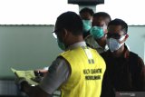 Petugas Kantor Kesehatan Pelabuhan memeriksa berkas persyaratan penumpang yang baru tiba di Bandara Banyuwangi, Jawa Timur, Sabtu (16/5/2020). Setelah aktivitas penerbangan ditutup untuk menghindari penyebaran wabah COVID-19, mulai hari ini penerbangan kembali dibuka dengan  menerapkan protokol pencegahan penularan COVID-19. Antara Jatim/Budi Candra Setya/zk