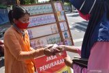Penjual melayani konsumen di Kota Madiun, Jawa Timur, Minggu (17/5/2020). Penjual jasa tersebut melayani penukaran uang pecahan dalam kondisi masih baru Rp2.000, Rp5.000, Rp10.000, Rp20.000 yang banyak dibutuhkan selama Lebaran dan memungut uang jasa 10 persen dari jumlah uang yang ditukarkan. Antara Jatim/Siswowidodo/zk.