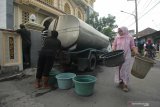 Warga mengantre air bersih yang dikirim oleh Pemkot Surabaya di kawasan Gunung Anyar Tambak, Surabaya, Jawa Timur, Senin (18/5/2020). Pengiriman itu untuk memenuhi kebutuhan air bersih warga yang terdampak akibat pipa air Perusahaan Daerah Air Minum (PDAM) Surya Sembada jebol akibat terkena tiang pancang proyek pembangunan kampus II Universitas Islam Negeri Sunan Ampel (UINSA) di Gunung Anyar, Surabaya. Antara Jatim/Didik/Zk