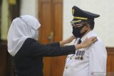 Gubernur Jawa Timur Khofifah Indar Parawansa (kiri) memasang tanda pangkat kepada Wali Kota Blitar Santoso saat pelantikan di Gedung Negara Grahadi, Surabaya, Jawa Timur, Selasa (19/5/2020). Santoso resmi menjabat sebagai Wali Kota Blitar untuk sisa masa jabatan periode 2016-2021 menggantikan M Samanhudi Anwar yang diberhentikan karena terbukti secara sah melakukan tindak pidana korupsi. Antara Jatim/Moch Asim/zk.