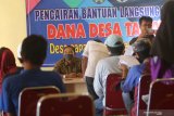 Warga kurang mampu terdampak pandemi COVID-19 antre mengambil bantuan sosial (bansos) Dana Desa di Desa Papar, Kediri, Jawa Timur, Rabu (20/5/2020). Pemerintah daerah setempat mengalokasikan 30 persen dari total anggaran pendapatan desa untuk bantuan langsung tunai yakni sebesar Rp600 ribu per bulan selama tiga bulan kepada kepala keluarga yang belum pernah mendapatkan bansos dari pemerintah pusat ataupun daerah. Antara Jatim/Prasetia Fauzani/zk