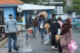 Pemudik berjalan menuju kapal di Pelabuhan Tanjungwangi, Banyuwangi, Jawa Timur, Rabu (20/5/2020). Kapal perintis KM Sabuk Nusantara 92, membawa 170 pemudik tujuan pulau Sapeken, Sumenep, dengan menerapkan protokol COVID-19 seperti kelengkapan dokumen kesehatan penumpang dan penerapan physical distancing  dengan cara membawa penumpang kurang dari 50 persen dari total kapasitas 450 penumpang. Antara Jatim/Budi Candra Setya/zk