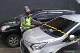 Polisi memasang garis polisi pada mobil travel ilegal yang ditahan di Cek Poin Pembatasan Sosial Berskala besar (PSBB) Balearjosari, Malang, Jawa Timur, Jumat (22/5/2020). Sebanyak empat unit mobil travel ilegal yang mengangkut penumpang dari Madura dan Surabaya tersebut ditahan karena melanggar larangan mudik dari pemerintah dan PSBB yang sedang dilaksanakan di kawasan Malang Raya sebagai upaya pencegahan penyebaran COVID-19. Antara Jatim/Ari Bowo Sucipto/zk