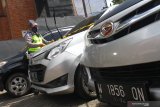 Polisi memasang garis polisi pada mobil travel ilegal yang ditahan di Cek Poin Pembatasan Sosial Berskala besar (PSBB) Balearjosari, Malang, Jawa Timur, Jumat (22/5/2020). Sebanyak empat unit mobil travel ilegal yang mengangkut penumpang dari Madura dan Surabaya tersebut ditahan karena melanggar larangan mudik dari pemerintah dan PSBB yang sedang dilaksanakan di kawasan Malang Raya sebagai upaya pencegahan penyebaran COVID-19. Antara Jatim/Ari Bowo Sucipto/zk