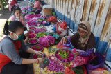 Penjual bunga tabur melayani pembeli di sebuah trotoar di Kota Madiun, Jawa Timur, Sabtu (23/5/2020). Menjelang Hari Raya Idul Fitri banyak penjual musiman dari Madiun dan sekitarnya berjualan bunga tabur yang banyak dibutuhkan warga untuk berziarah kubur, dan dijual antara Rp20.000 hingga Rp25.000 per paket. Antara Jatim/Siswowidodo/zk.