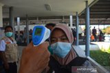 Petugas melakukan pemeriksaan suhu tubuh pemudik yang turun di Stasiun Kabupaten Jombang, Jawa Timur, Sabtu (23/5/2020). Untuk memaksimalkan pengawasan gelombang pemudik lokal, PT KAI Daop 7 Madiun memutuskan perjalanan Kereta Api lokal dari Surabaya hanya berhenti di stasiun Jombang hingga 31 Mei mendatang. Hal itu dilakukan sebagai upaya pencegahan penyebaran COVID-19 selama Lebaran. Antara Jatim/Syaiful Arif/zk