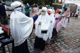 Petugas memeriksa suhu tubuh warga ketika memasuki halaman Masjid Haqqul Yaqin Tambaksawah, Sidoarjo, Jawa Timur, Minggu (24/5/2020). Masjid tersebut tetap melaksanakan shalat id dengan menerapkan protokol kesehatan seperti setiap jamaah wajib mengenakan masker, pemeriksaan suhu tubuh dan shaf yang berjarak satu meter. Antara Jatim/Naufal Ammar/zk.