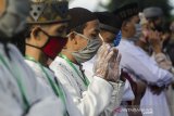 Warga mengikuti pelaksanaan Shalat Id dengan menggunakan masker di Baleendah, Kabupaten Bandung, Jawa Barat, Minggu (24/5/2020). Warga di kawasan tersebut melaksanakan Shalat Idul Fitri 2020 dengan menerapkan protokol kesehatan seperti penggunaan masker, sarung tangan, disemprot disinfektan serta pemberian batas dan jarak guna mengurangi resiko terpapar virus COVID-19. ANTARA JABAR/Novrian Arbi/agr