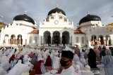 Umat muslim memadati Masjid Raya Baiturrahman untuk melaksanakan ibadah shalat Id atau sembahyang hari Raya Idul Fitri di Masjid Raya Baiturrahman, Banda Aceh, Aceh, Minggu (24/5/2020). Mayoritas umat muslim di daerah yang telah memberlakukan hukum syariat islam tetap melaksanakan sembahyang hari raya di masjid-masjid meski Pemerintah setempat telah mengeluarkan imbauan untuk menjaga protokol kesehatan guna mengantisipasi penyebaran dan penularan COVID-19. Antara Aceh/Irwansyah Putra.