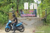 Seorang pengendara motor memutar balik karena jalan masuk ditutup di Kelurahan Banua Anyar, Banjarmasin, Kalimantan Selatan, Senin (25/5/2020). Warga Kelurahan Banua Anyar di lima RT melakukan isolasi mandiri untuk mencegah keluar masuknya orang dalam upaya memutus mata rantai penyebaran COVID-19. Foto Antaranews Kalsel/Bayu Pratama S.