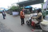 Relawan memberhentikan pengendara motor yang tidak menggunakan masker saat hendak masuk ke kampung Banua Anyar di posko COVID-19 Banua Anyar, Banjarmasin, Kalimantan Selatan, Senin (25/5/2020). Warga Kelurahan Banua Anyar di lima RT melakukan isolasi mandiri untuk mencegah keluar masuknya orang dalam upaya memutus mata rantai penyebaran COVID-19. Foto Antaranews Kalsel/Bayu Pratama S.