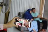 Sebuah keluarga di Kota Pekanbaru, Provinsi Riau, melakukan silaturahmi secara virtual dengan keluarga di Kota Depok, Jawa Barat, saat Hari Raya Idul Fitri 1441 Hijriah, Minggu (24/5/2020). Sebagian besar masyarakat memutuskan tidak mudik Lebaran untuk mencegah penyebaran COVID-19, dan menggunakan teknologi video conference untuk bersilaturahmi. ANTARA FOTO/FB Anggoro/foc.