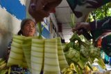 Penjual musiman cangkang ketupat melakukan aktivitas di Pasar Sleko, Kota Madiun, Jawa Timur, Senin (25/5/2020). Harga cangkang ketupat di pasar tersebut melonjak dibanding tahun sebelumya antara Rp5.000-Rp6.000 menjadi Rp10.000-Rp15.000 per ikat berisi 10 buah tergantung ukuran, yang menurut penjual karena kesulitan mendapatkan bahan daun kelapa akibat banyak wilayah desa yang tertutup untuk kendaraan angkutan sebagai upaya pencegahan penularan COVID-19. Antara Jatim/Siswowidodo/zk