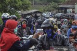 Petugas memeriksa pengendara di pos pemeriksaan (check point) di perbatasan Kabupaten Tasikmalaya dengan Kabupaten Ciamis, Jawa Barat, Selasa (26/5/2020). Pemeriksaan tersebut sebagai upaya penyekatan pemudik lokal yang hendak keluar-masuk Provinsi Jabar dan juga para pelancong ke tempat wisata di daerah masing-masing yang rentan penyebaran COVID-19. ANTARA JABAR/Adeng Bustomi/agr