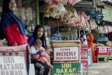 Pedagang menjual oleh-oleh dan jajanan khas Jawa Barat di Nagreg, Kabupaten Bandung, Jawa Barat, Rabu (27/5/2020). Pedagang oleh-oleh di kawasan tersebut mengalami penurunan omset  80 hingga 90 persen menjadi Rp. 80 ribu perhari dari penjualan pada musim arus mudik dan arus balik pada tahun lalu yang mencapai Rp. 5 Juta perhari karena terdampak larangan mudik dan PSBB Pandemi COVID-19. ANTARA JABAR/Novrian Arbi/agr