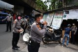 Anggota Ditsamapta Polda Metro Jaya melakukan sosialisasi protokol kesehatan di Pasar Pagi Asemka, Jakarta Barat, Rabu (27/5/2020). Sosialisasi protokol kesehatan di sektor niaga tersebut untuk menuju tatanan normal baru sehingga masyarakat dapat dan terbiasa menjalankan protokol yang telah ditetapkan pemerintah. ANTARA FOTO/Sigid Kurniawan/nym.