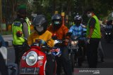 Petugas kesehatan melakukan pemeriksaan suhu tubuh pengendara motor yang melintas di depan pos Keplaksari, Kecamatan Peterongan, Kabupaten Jombang, Jawa Timur, Kamis (28/5/2020). Pemeriksaan tersebut untuk mengantisipasi peningkatan penyebaran virus Corona (COVID-19) di Kabupaten Jombang, karena banyak masyarakat yang sudah mulai kembali beraktivitas di luar rumah. Antara Jatim/Syaiful Arif/zk