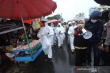 Petugas gabungan menggunakan Alat Pelindung Diri (APD) memberikan edukasi penerapan protokol kesehatan kepada masyarakat di Pasar Lama, Banjarmasin, Kalimantan Selatan, Kamis (28/5/2020). Gugus Tugas Percepatan Penangan COVID-19 Provinsi Kalimantan Selatan mengerahkan 324 petugas gabungan terdiri dari Satpol PP, TNI dan Polri untuk menjaga serta memberikan edukasi kepada masyarakat terkait penerapan protokol kesehatan di pasar-paaar tradisional. Foto Antaranews Kalsel/Bayu Pratama S.