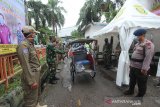 Petugas gabungan berjaga di depan Pasar Sentra Antasari, Banjarmasin, Kalimantan Selatan, Kamis (28/5/2020). Gugus Tugas Percepatan Penangan COVID-19 Provinsi Kalimantan Selatan mengerahkan 324 petugas gabungan terdiri dari Satpol PP, TNI dan Polri untuk menjaga serta memberikan edukasi kepada masyarakat terkait penerapan protokol kesehatan di pasar-paaar tradisional. Foto Antaranews Kalsel/Bayu Pratama S.