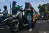 Petugas kesehatan melakukan pemeriksaan suhu tubuh pengendara motor yang melintas di depan pos Keplaksari, Kecamatan Peterongan, Kabupaten Jombang, Jawa Timur, Kamis (28/5/2020). Pemeriksaan tersebut untuk mengantisipasi peningkatan penyebaran virus Corona (COVID-19) di Kabupaten Jombang, karena banyak masyarakat yang sudah mulai kembali beraktivitas di luar rumah. Antara Jatim/Syaiful Arif/zk