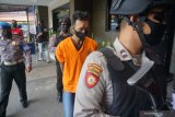 Petugas menggiring tersangka bandar narkoba lintas wilayah di Mapolres Tulungagung, Jawa Timur, Kamis (28/5/2020). Satuan narkoba polres Tulungagung berhasil mengamankan barang bukti narkoba jenis sabu seberat 200 gram (2 ons), 188 butir pil ekstasi (XTC), 9 butir piskotropika jenis mersi clonaszepam dan uang sebesar Rp1.5 juta. Antara Jatim/Destyan Sujarwoko/zk