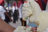 Petugas kesehatan mengambil sampel darah pekerja saat tes diagnostik cepat (rapid test) COVID-19 di sebuah pabrik rokok di Kabupaten Madiun, Jawa Timur, Rabu (27/5/2020). Rapid test yang dilakukan terhadap 890 pekerja di pabrik rokok tersebut dimaksudkan untuk mencegah penyebaran COVID-19 menyusul ditemukannya seorang pekerja terkonfirmasi positif COVID-19 di pabrik rokok tersebut. Antara Jatim/Siswowidodo/zk