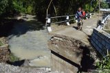 Warga melihat bagian jembatan yang putus di Desa Ketandan, Kecamatan Dagangan, Kabupaten Madiun, Jawa Timur, Jumat (29/5/2020). Menurut warga, jembatan tersebut putus akibat diterjang banjir yang terjadi Kamis (28/5). Antara Jatim/Siswowidodo/zk