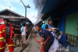 Sejumlah petugas pemadam kebakaran berupaya memadamkan api yang membakar rumah di kawasan jalan Manggis, Banjarmasin, Kalimantan Selatan, Jumat (29/5/2020). Sebanyak empat rumah warga dan satu bedakan lima pintu hangus terbakar di kawasan permukiman padat penduduk tersebut, dimana penyebab kebakaran masih dalam penyelidikan kepolisian. Foto Antaranews Kalsel/Bayu Pratama S.