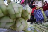 Pedagang musiman merangkai janur menjadi kulit ketupat di pasar Setono Bethek, Kota Kediri, Jawa Timur, Jumat (29/5/2020). Menjelang tradisi Lebaran Ketupat yang biasanya dimulai pada hari ke enam Idul Fitri, anyaman janur sebagai kulit ketupan seharga Rp15.000 per sepuluh buah tersebut ramai diburu warga. Antara Jatim/Prasetia Fauzani/zk