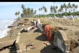 Warga melintas disamping makam etnis Tionghoa yang rusak akibat gelombang pasang di Desa Suak Ribee, Kecamatan Johan Pahlawan, Aceh Barat, Aceh, Sabtu (30/5/2020). Menurut keterangan Kepala Desa Suak Ribee Teuku Razali menjelaskan, sejak dua pekan terakhir sebanyak 20 makam etnis tionghoa rusak akibat tergerus gelombang pasang. ANTARA FOTO/Syifa Yulinnas/nym.