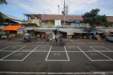 Warga melintas di antara petak-petak untuk tempat pedagang di depan Pasar Pegirian, Surabaya, Jawa Timur, Jumat (29/5/2020). Petak-petak yang dibuat untuk menjaga jarak antar pedagang saat berjualan sekaligus sebagai upaya mencegah penyebaran COVID-19 tersebut tidak ditempati pada Jumat, 29 Mei 2020 karena kondisi cuaca dan kurangnya kesadaran masyarakat dalam menerapkan 