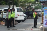 Anggota Polisi berjaga di pintu masuk Pasar Sudimampir di Banjarmasin, Kalimantan Selatan, Senin (1/6/2020). Pemerintah Kota Banjarmasin menghentikan pemberlakuan Pembatasan Sosial Berskala Besar (PSBB) pada Minggu (31/5/2020) dan memberlakukan Kondisi Tanggap Darurat COVID-19 Pasca PSBB serta memberikan edukasi protokol kesehatan yang merupakan tahapan menuju normal baru (New Normal) kepada masyarakat. Foto Antaranews Kalsel/Bayu Pratama S.