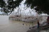 Warga beriswata di tempat penambatan bagan dan perahu di Pantai Desa Montok, Pamekasan, Jawa Timur, Senin (1/6/2020).  Warga memanfaatkan tempat penambatan perahu dan bagan guna mengisi libur lebaran ketupat  karena ditutupnya sejumlah tempat wisata akibat Pandemi COVID-19. Antara Jatim/Saiful Bahri/zk.