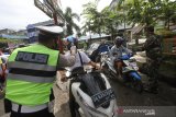 Anggota Polisi dan TNI melakukan pengecekan suhu tubuh kepada pengunjung Pasar Sentra Antasari di Banjarmasin, Kalimantan Selatan, Senin (1/6/2020). Pemerintah Kota Banjarmasin menghentikan pemberlakuan Pembatasan Sosial Berskala Besar (PSBB) pada Minggu (31/5/2020) dan memberlakukan Kondisi Tanggap Darurat COVID-19 Pasca PSBB serta memberikan edukasi protokol kesehatan yang merupakan tahapan menuju normal baru (New Normal) kepada masyarakat. Foto Antaranews Kalsel/Bayu Pratama S.