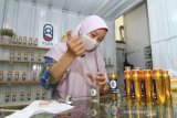 Pedagang bibit parfum Amy mengisi botol parfum isi ulang di gerai Flos miliknya di Jalan Putri Daranante, Pontianak, Kalimantan Barat, Senin (1/6/2020). Beragam bibit parfum beraroma wangi tersebut dijual seharga Rp1.800 hingga Rp10 ribu per mililiter. ANTARA FOTO/Jessica Helena Wuysang