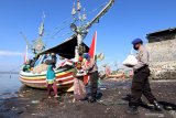 Anggota Polairud Polresta Banyuwangi memberikan bantuan sembako kepada masyarakat nelayan di pesisir Muncar, Banyuwangi, Jawa Timur, Selasa (2/6/2020). Bantuan sembako untuk  masyarakat pesisir terdampak cuaca buruk dimasa Pandemi  COVID-19 yang belum mendapatkan bantuan dari pemerintah itu, sebagai upaya dalam meringankan beban ekonomi masyarakat nelayan. ANtara Jatim/Budi Candra Setya/zk