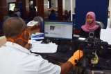 Petugas melakukan perekaman Kartu Tanda Penduduk (KTP) Elektronik di gedung pusat pelayanan publik Pemkab Madiun, Jawa Timur, Rabu (3/6/2020). Dinas Kependudukan dan Pencatatan Sipil setempat membatasi pelayanan permohonan perekaman KTP Elektronik maksimal 20 pemohon per hari karena harus dilakukan dengan protokol kesehatan dalam upaya pencegahan penyebaran COVID-19 antara lain dengan menjaga jarak. Antara Jatim/Siswowidodo/zk