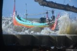 Perahu dihempas ombak di Pantai kampung nelayan Kotasek,  Pamekasan, Jawa Timur, Kamis (4/6/2020). Dalam dua hari terakhir, gelombang tinggi dan angin kencang di daerah itu, menyebabkan sebuah rumah rusak dan sejumlah pemukiman tergenang banjir rob. Antara Jatim/Saiful Bahri/zk