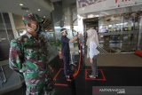 Anggota TNI berjaga di pintu masuk Q-Mall, Banjarbaru, Kalimantan Selatan, Jumat (5/6/2020). Pengelola pusat perbelanjaan tersebut menerapkan protokol kesehatan secara ketat berupa kewajiban mencuci tangan, pemeriksaan suhu tubuh, penggunaan masker, dan menyediakan fasilitas pendukung jaga jarak fisik (pshycal distancing) bagi pengunjung maupun karyawan guna mendukung pemerintah disaat kehidupan normal baru (New Normal). Foto Antaranews Kalsel/Bayu Pratama S.