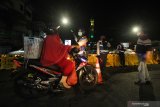 Petugas meminta pengendara kendaraan bermotor untuk berputar balik di Jalan Rungkut Menanggal, Surabaya, Jawa Timur, Kamis (4/6/2020). Jalan penghubung Kota Surabaya-Sidoarjo itu ditutup sementara untuk menekan penyebaran COVID-19. Antara Jatim/Didik/Zk