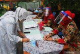 Dua guru menggunakan pelindung wajah (face shield) dan masker saat melayani orang tua siswa dalam verifikasi Pendaftaran Peserta Didik Baru menjelang Tahun Ajaran Baru di SMPN 1, Malang, Jawa Timur, Jumat (5/6/2020). Pemerintah menetapkan jadwal tahun ajaran baru tetap yakni pada tanggal 13 Juli 2020 namun kegiatan belajar mengajar tanpa tatap muka. Antara Jatim/Ari Bowo Sucipto/zk