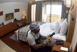 Pekerja hotel menggunakan alat pelindung diri saat menyiapkan kamar di Hotel Inaya Putri Bali, Nusa Dua, Badung, Bali, Jumat (5/6/2020). Menjelang penerapan tatanan hidup normal baru, hotel tersebut menerapkan protokol kesehatan seperti dengan penggunaan alat pelindung diri, melakukan penyemprotan cairan disinfektan secara rutin, memeriksa suhu tubuh tamu hotel, memberi jarak antar kursi di restoran serta menyiapkan menu makanan secara digital sebagai upaya pencegahan penyebaran COVID-19. ANTARA FOTO/Fikri Yusuf/nym.
