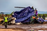 Petugas gabungan menutup bangkai helikopter yang jatuh menggunakan terpal di Kawasan Industri Kendal (KIK), Kabupaten Kendal, Jawa Tengah, Sabtu (6/6/2020). Belum diketahui penyebab jatuhnya helikopter jenis MI-17 bernomor registrasi HA 5141 milik TNI-AD yang mengakibatkan empat awak tewas dan lima awak lainnya dilarikan ke rumah sakit. ANTARA FOTO/Aji Styawan/wsj.