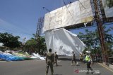 Petugas Satpol PP menurunkan baliho yang terpasang di Jalan Ahmad Yani, Banjarmasin, Kalimantan Selatan, Senin (8/6/2020). Satpol PP Kota Banjarmasin menurunkan 10 baliho yang terpasang di papan reklame di jalan Ahmad Yani karena izin papan reklame tersebut  sudah habis sejak tahun 2018. Foto Antaranews Kalsel/Bayu Pratama S.