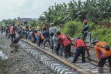 Sejumlah pekerja memasang bantalan rel baru di jalur perlintasan kereta api di kawasan Awipari, Kota Tasikmalaya, Jawa Barat, Senin (8/6/2020). Satuan Kerja (Satker) Balai Teknik Perkeretaapian Wilayah Jawa Bagian Barat melaksanakan peningkatan jalur kereta api mulai Stasiun Ciawi, Tasikmalaya hingga Stasiun Banjar sepanjang 42 kilometer untuk meningkatkan kenyamanan dan keamanan perjalanan kereta yang melintas di jalur selatan Jawa. ANTARA JABAR/Adeng Bustomi/agr